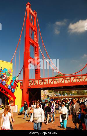 Guests walk under a model of the Golden Gate Bridge as they enter the California Adventure theme and amusement park at Disneyland Stock Photo