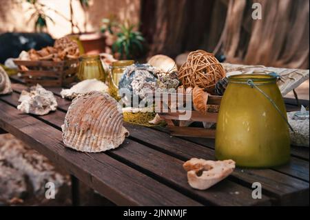 Wooden table in backyard decorated with shells and fishing equipment Stock Photo