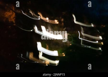 Close up shot of Several different colored lines moving in the dark. Camera movement. Stock Photo