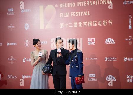 Beijing, China. 12th Aug, 2022. Actor Louis Koo (C) receives an interview on the red carpet of the 12th Beijing International Film Festival in Beijing, capital of China, Aug. 12, 2022. Credit: Chen Zhonghao/Xinhua/Alamy Live News Stock Photo