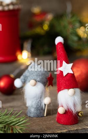 Vintage Christmas postcard design. Christmas gnomes with fir tree, christmas lights and red christmas baubles decorations. Stock Photo