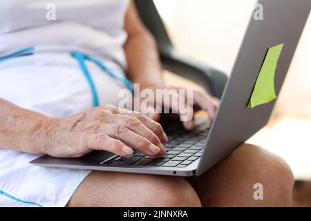 Old woman hands typing on modern laptop Stock Photo
