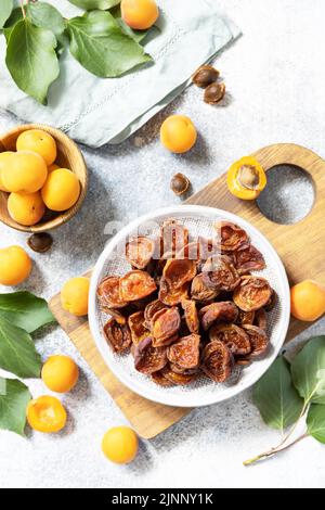 Dried fruits. Dried apricots and raw apricots on a gray stone background. View from above. Stock Photo