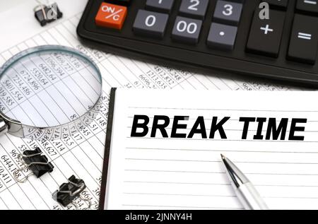 Business concept. On the table is a magnifying glass, a calculator, a pen and a notebook with the inscription - Break Time Stock Photo