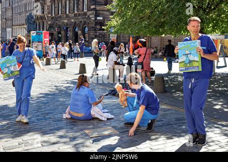 Edinburgh, Scotland, August 11,2022 Festival Fringe group of  protesting medics and placard with writing NHS Cutbacks have not stopped us Stock Photo