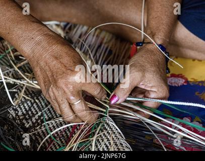 Central Kalamantan, Indonesia; May 20, 2022 - Woman makes baskets by hand. Stock Photo