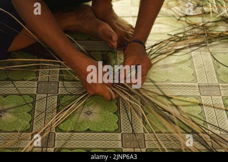 Central Kalamantan, Indonesia; May 20, 2022 - Woman makes baskets by hand. Stock Photo