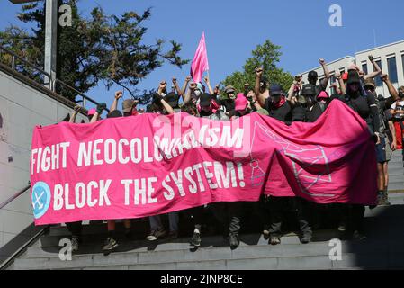 Hamburg, Germany. 13th Aug, 2022. Climate activists and climate camp participants walk into Altona train station during a demonstration. Credit: Bodo Marks/dpa/Alamy Live News Stock Photo