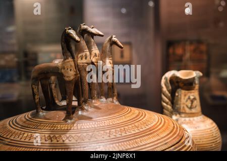 Close up of a pottery pyxis with four horses on the lid inside the Cycladic Art museum in Athens Stock Photo