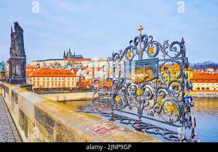 The lace-like grille decorated with plaque with St John Nepomuk bas relief on Charles Bridge, Prague, Czech Republic Stock Photo