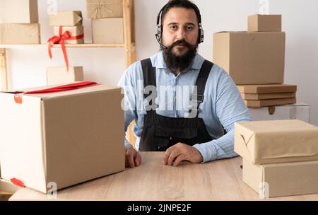 Startup business, telemarketing indian small business owner in headphones looking at camera, entrepreneur taking online store order, e-commerce Stock Photo