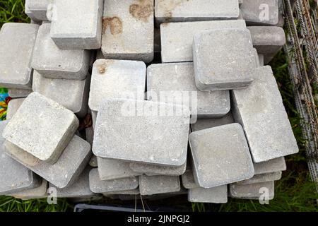 Stack of bricks for home construction, top view. Gray color paving slabs. Selective focus, blurred background Stock Photo