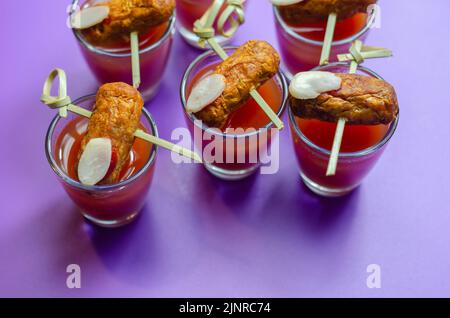 Bloody Mary cocktails in the shots drink served with Halloween bloody fingers, pork cocktail sausages decorated with flaked almonds, funny food Stock Photo