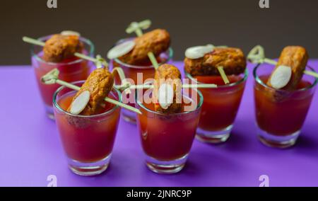 Bloody Mary cocktails in the shots drink served with Halloween bloody fingers, pork cocktail sausages decorated with flaked almonds, funny food Stock Photo