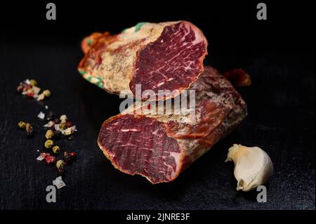 Iberian loin on black slate with peppercorns and garlic Stock Photo