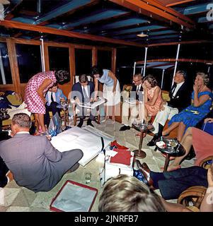 President John F. Kennedy opening gifts with family and friends on board the presidential yacht - the USS Sequoia May 29, 1963 Stock Photo