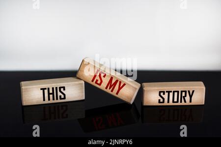 The symbol of my history. Words This is my story written on wooden blocks and white and black background with reflection. Business and my story concep Stock Photo