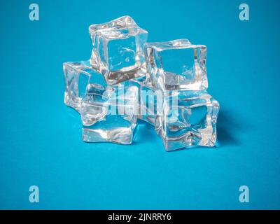 a batch of ice cubes on a blue background. Summer concept. Stock Photo