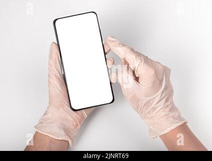Hand in gloves holding mobile phone screen mockup, pov. High quality photo Stock Photo