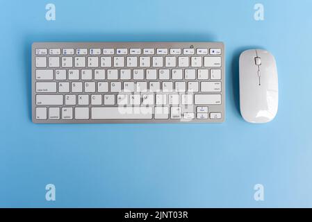 Computer keyboard and mouse on top of blue background desk Stock Photo