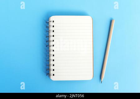 Note pad and pencil on blue background Stock Photo