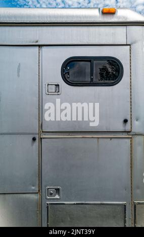 The compartment doors on the side of a silver metallic horse trailer Stock Photo