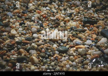 Texture formed by boulders on the shore of the beach, wet and gray and ocher colors Stock Photo