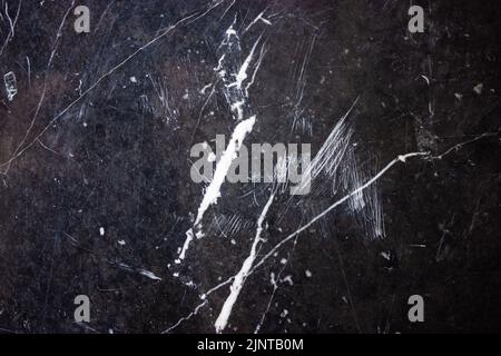 Black and white marble tile pattern texture. Dark gray abstract background with white blurred stripes, spots, scratches. Natural stone surface, wall, Stock Photo