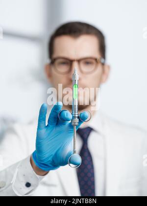 Closeup shot of syringe in hands of a male doctor Stock Photo