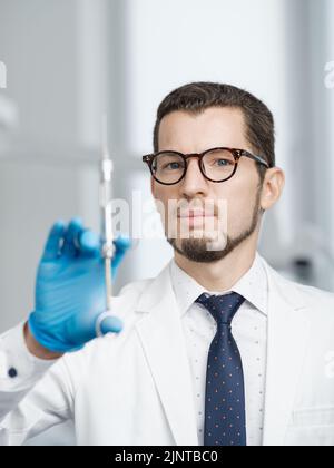 Closeup portrait of male doctor holding cartridge syringe Stock Photo