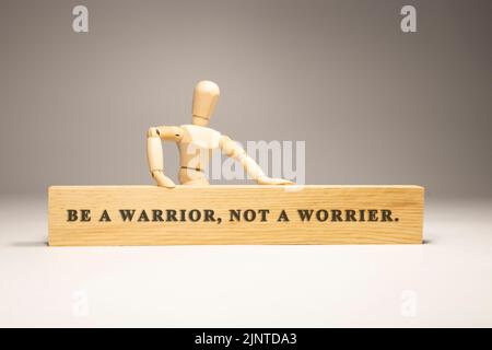 Be a warrior, not a worrier written on wooden surface. Motivation and personal development Stock Photo