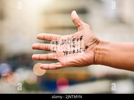 Heres some inspiration for you. a woman showing a motivational message written on her hand. Stock Photo