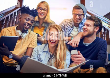 This is all for our future. a group of diverse university students working together on the staircase on campus. Stock Photo
