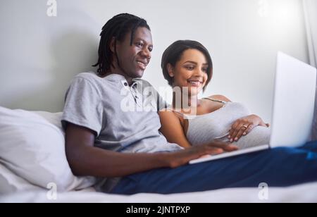 Lets check what this week of pregnancy holds. an expecting couple browsing the internet at home. Stock Photo