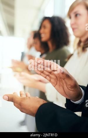 Thats won their approval. an unrecognizable businessman and his colleagues applauding while standing in line during a seminar. Stock Photo