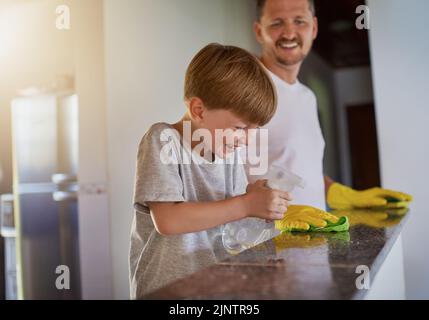 Hes always been helpful around the house. a father and his little son doing chores together at home. Stock Photo