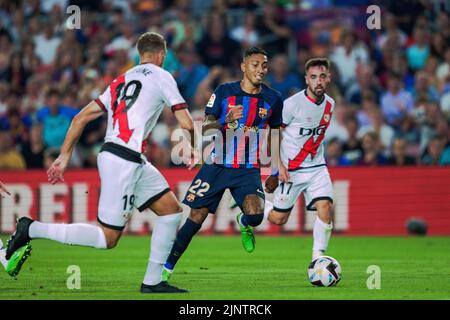 Barcelona, Spain. 13th Aug, 2022. Barcelona's Raphinha (C) vies with Vallecano's Florian Lejeune (L) during a La Liga Santander match between FC Barcelona and Rayo Vallecano in Camp Nou, Barcelona, Spain, on Aug. 13, 2022. Credit: Joan Gosa/Xinhua/Alamy Live News Stock Photo