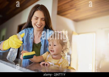 Simple chores can help them learn responsibility from an early age. a mother and her little daughter doing chores together at home. Stock Photo