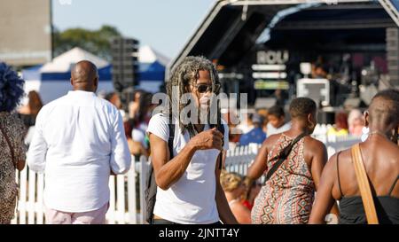 A black male with greying dreadlocks dances at an open air, outdoor festival celebrating Jamaican Independence and Southend gaining City status. Stock Photo