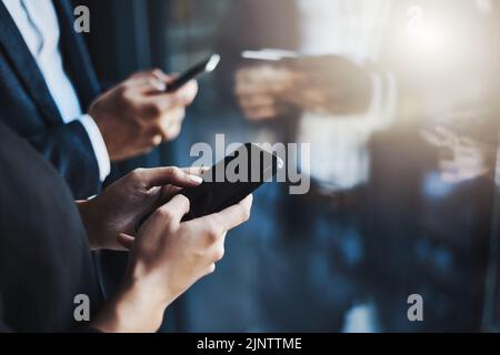 They know what connections they need to make to stay successful. Closeup shot of two unrecognizable businesspeople using their cellphones in an office Stock Photo
