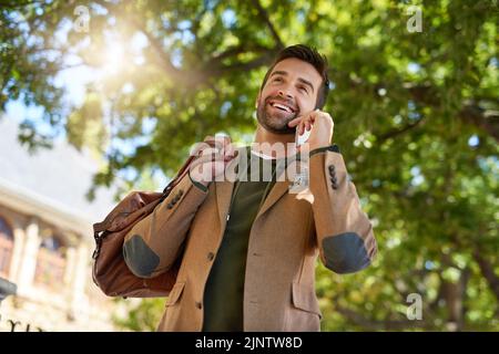 Yep, Im just heading out. a handsome young man making a phonecall during his morning commute. Stock Photo