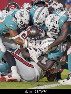 Tampa, United States. 13th Aug, 2022. Miami Dolphins defenders gang tackle Tampa Bay Buccaneers running back Ke'Shawn Vaughn (21) during the first half of their preseason game at Raymond James Stadium in Tampa, Florida on Saturday, August 13, 2022. Photo by Steve Nesius/UPI Credit: UPI/Alamy Live News Stock Photo