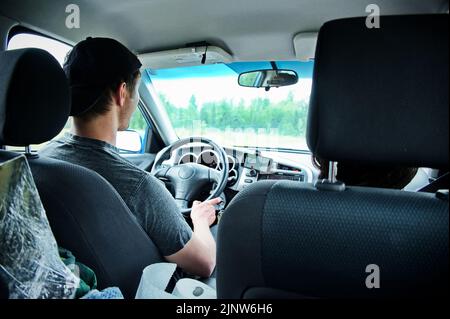 Mature man driving a car and using mobile navigation Stock Photo