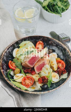 Plated salad bowl. Meat, boiled eggs, vegetables and greens mixed together in a beautiful harmony of tasle. Close up. Stock Photo