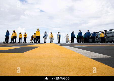 Pacific Ocean. 28th July, 2022. Sailors and Marines perform a foreign object debris (FOD) walk-down on the flight deck aboard amphibious assault carrier USS Tripoli (LHA 7), July 29, 2022. Tripoli is operating in the U.S. 7th Fleet area of operations to enhance interoperability with allies and partners and serve as a ready response force to defend peace and maintain stability in the Indo-Pacific region. Credit: U.S. Navy/ZUMA Press Wire Service/ZUMAPRESS.com/Alamy Live News Stock Photo