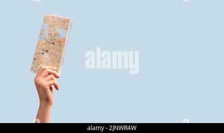 Abstract paper map in hand on blue background with copy space. High quality photo Stock Photo