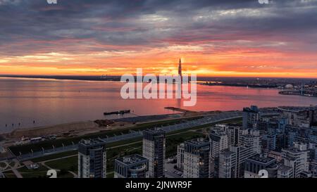 The Gulf of Finland and the sun setting behind the Lakhta Center tower. Red sunset over Saint Petersburg, Russia panoramic aerial view. Stock Photo