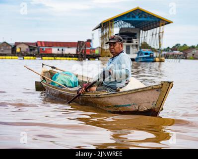 Central Kalamantan, Indonesia, May 20, 2022 - Man rows his boat across the river. Stock Photo