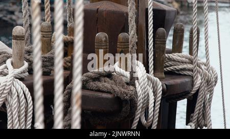 Ropes wound on holders on a wooden sailing ship Stock Photo