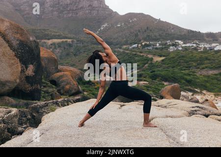 Full length of young fit woman practicing yoga outdoors Stock Photo